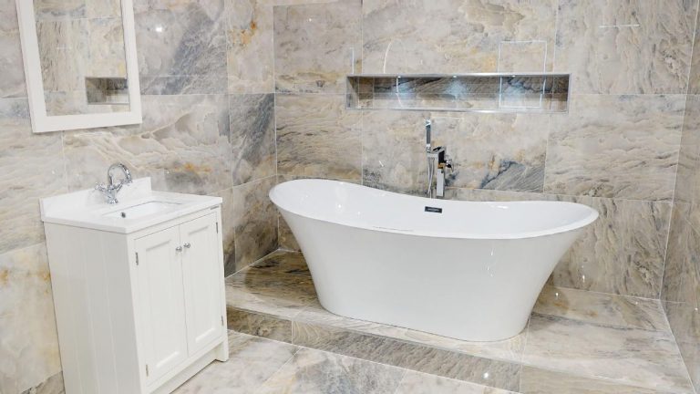 Marble effect wall tiles behind a freestanding bath