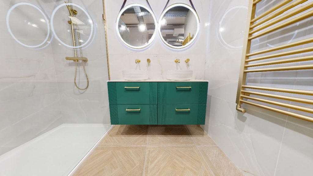 Green wall-hung vanity unit with gold handles and round mirrors